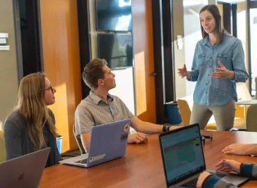 Sala de juntas con laptops y personas jóvenes